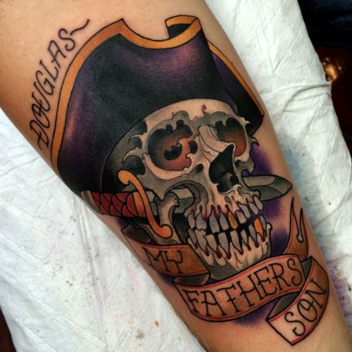 Neo traditional colored forearm tattoo of pirate skull with dagger and lettering