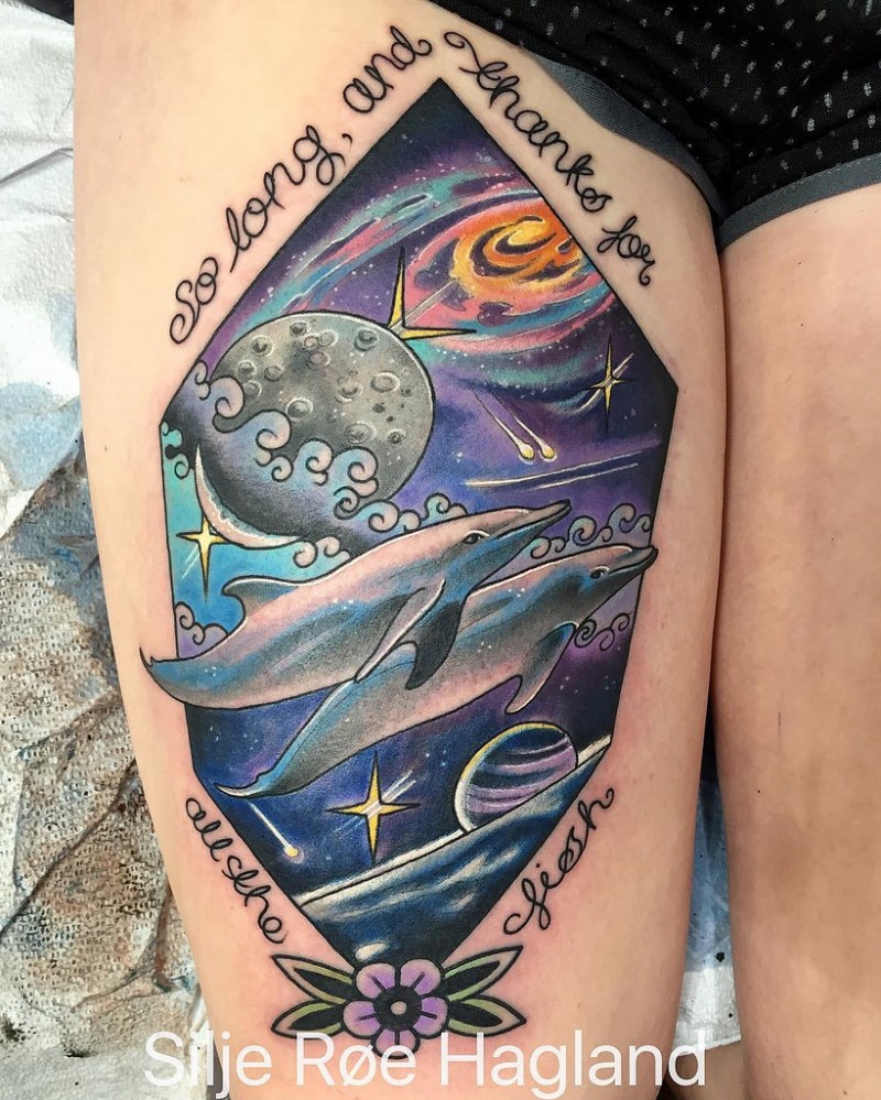 Neo traditional style colored thigh tattoo of dolphins swimming in space with lettering