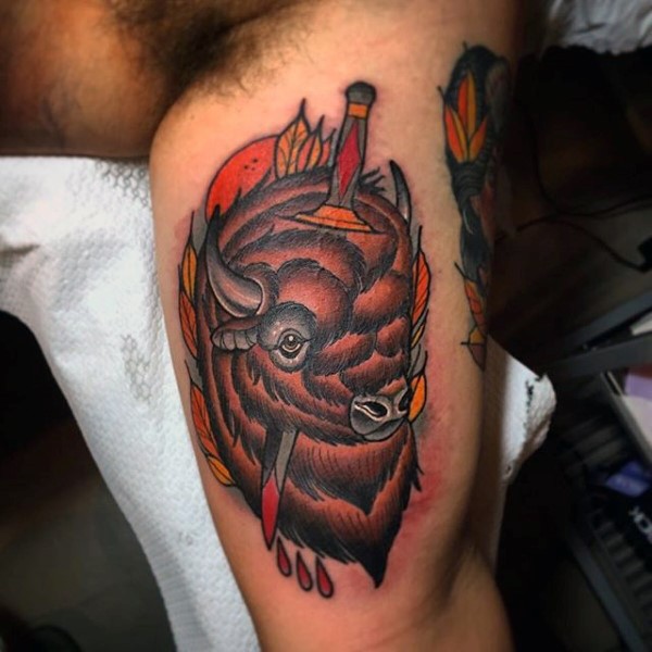 New school style colored biceps tattoo of bull with bloody knife