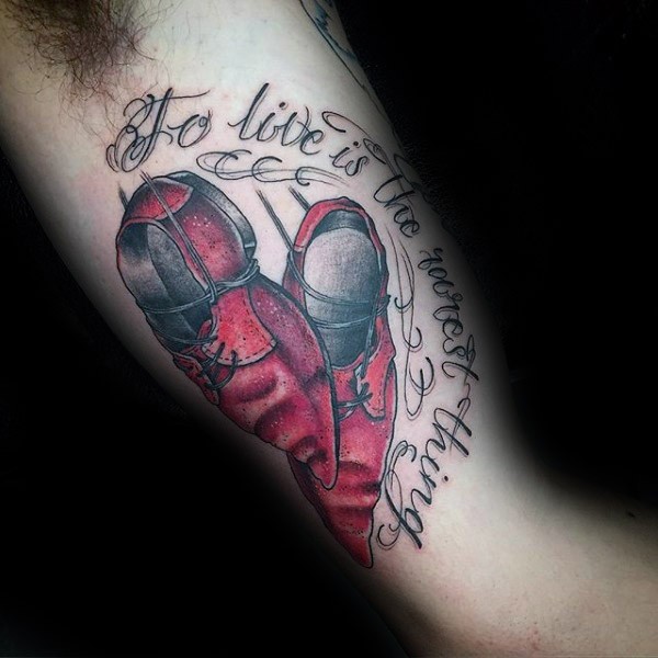 New school style colored biceps tattoo of magical boots and lettering