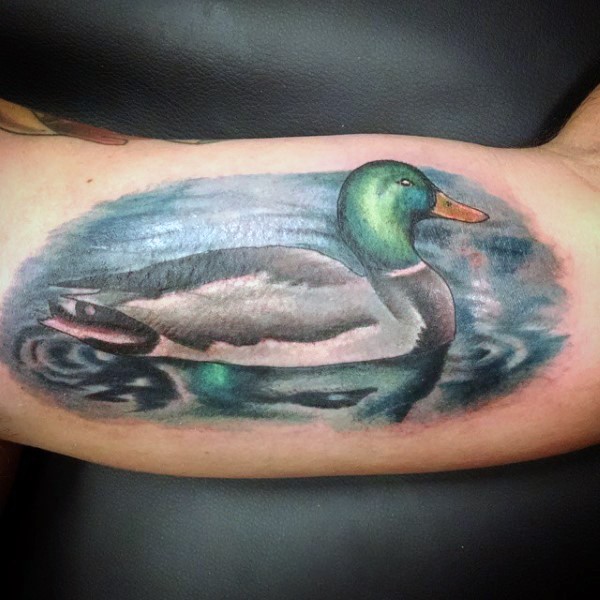New school style colored biceps tattoo of swimming duck