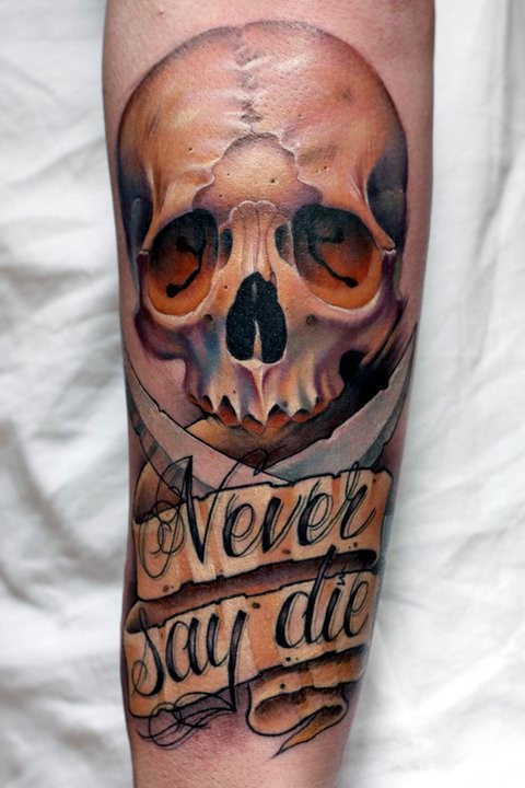 New school style colored detailed human skull tattoo on forearm with lettering