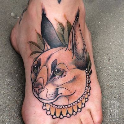 New school style colored foot tattoo of saint caracal with jewelry