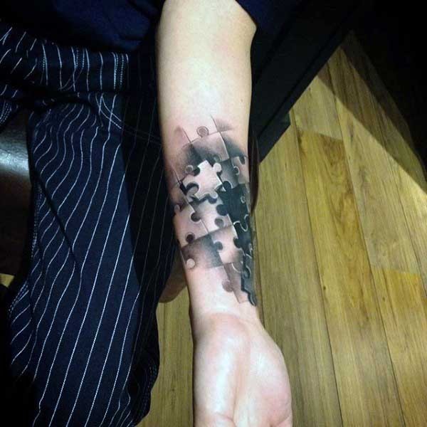 New school style colored forearm tattoo of puzzle pieces
