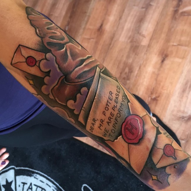 New school style colored forearm tattoo of Harry Potter movie letter