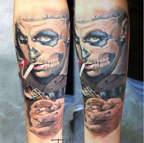 New school style colored forearm tattoo of man with skull face and lettering