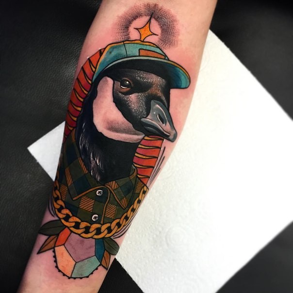 New school style colored forearm tattoo of bird with golden chain