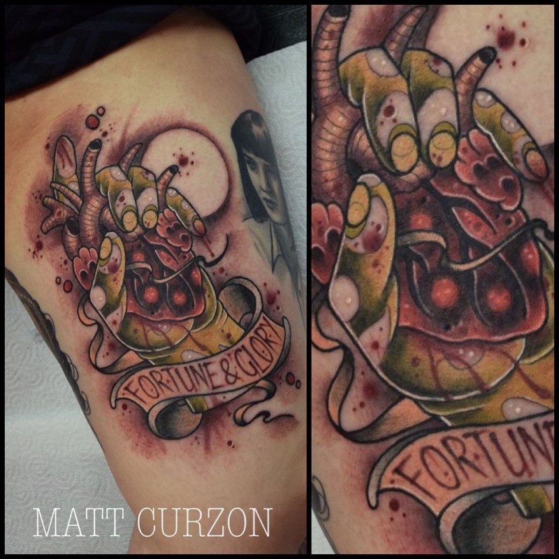 New school style colored thigh tattoo of zombie hand with bloody heart and lettering