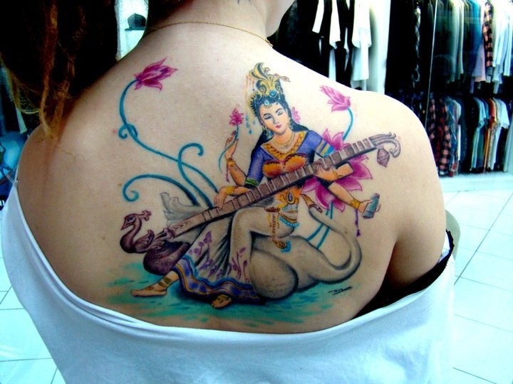 Nice and beautiful looking colored upper back tattoo of Hinduism woman with music instrument