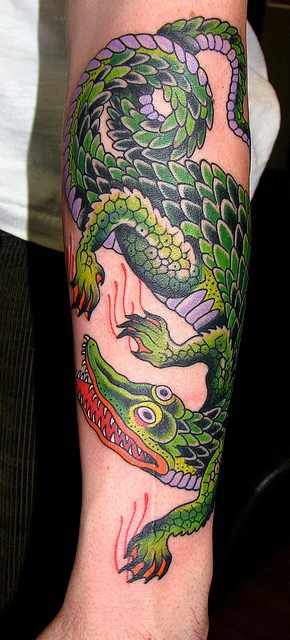 Nettes cartoonisches farbiges großes detailliertes Alligator Tattoo am Arm