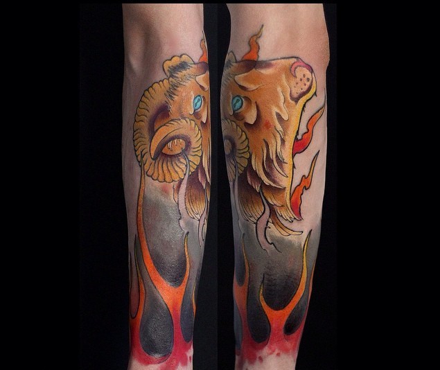 Nice colored cartoon like goat head tattoo on forearm stylized with flames