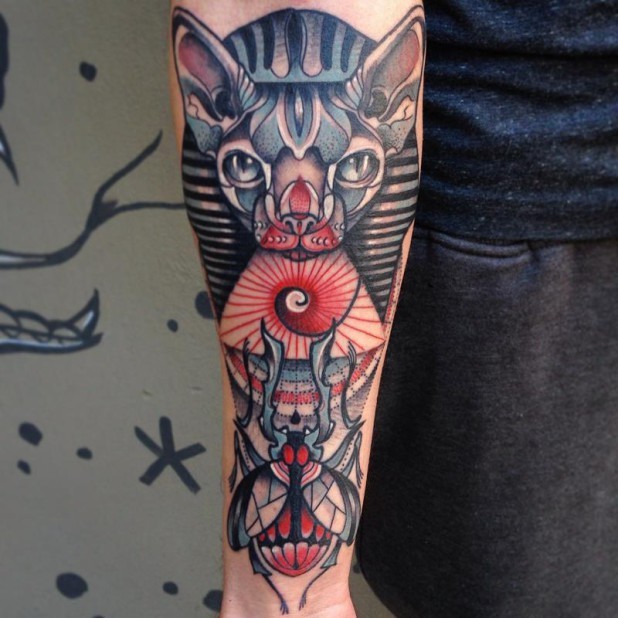 Nice colored Egypt themed colored cat tattoo on forearm with little bug