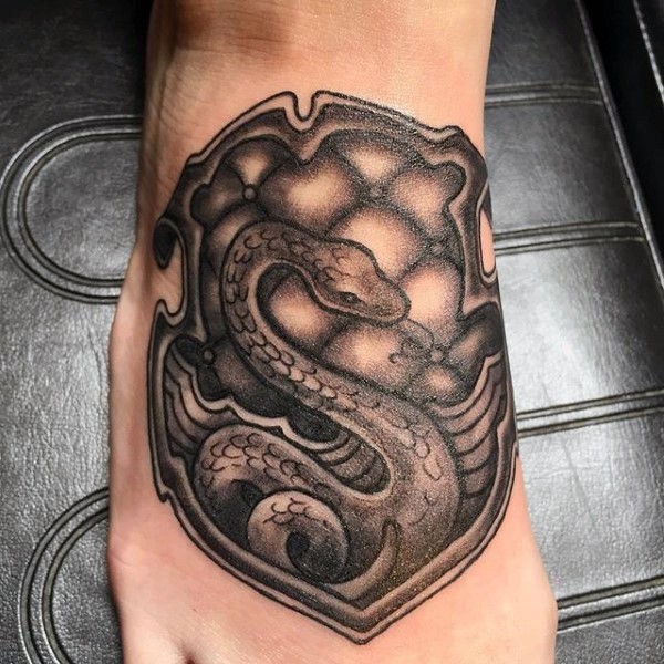Nice family crest like little shield with snake tattoo on foot