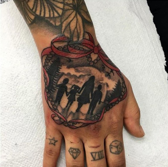 Tatuaje en la mano,  silueta de  familia y la luna llena