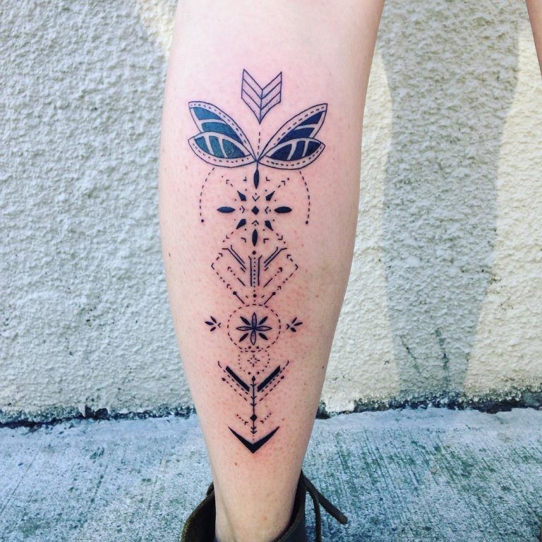 Nice looking arrow shaped black ink tattoo on leg stylized with various ornaments