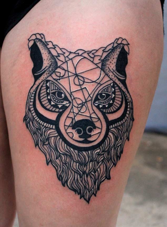 Nice looking black and white wolf tattoo on thigh stylized with geometrical ornaments
