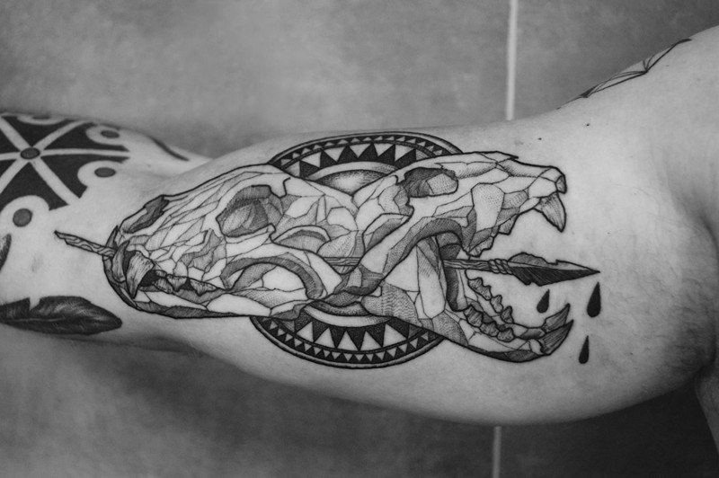 Tatuaje en el brazo,
 cráneos de animales perforados por flecha