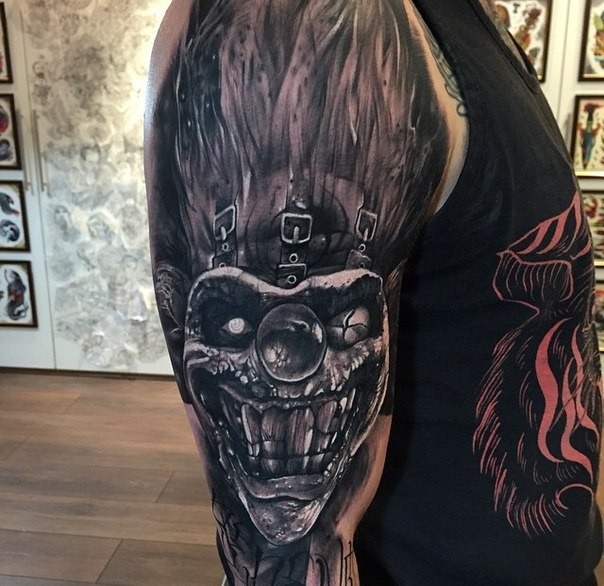 Nice looking colored arm tattoo of crazy monster clown face