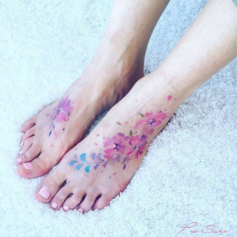 Nice looking colored feet tattoo of beautiful flowers