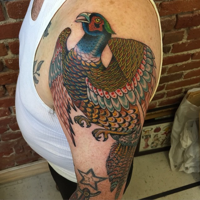 Nice looking colored shoulder tattoo of beautiful bird