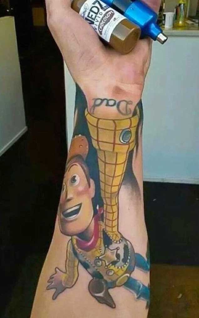 Nett aussehender farbiger Toy Story Cowboy Held Tattoo am Unterarm mit Schriftzug