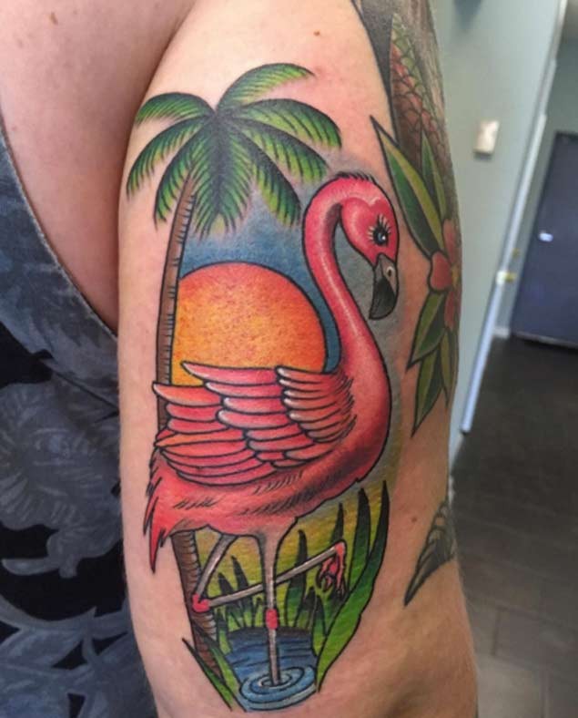 Nice looking colorful upper arm tattoo of flamingo with palm tree and sun