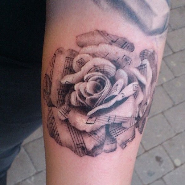 Nice music themed very detailed black and white rose tattoo on arm