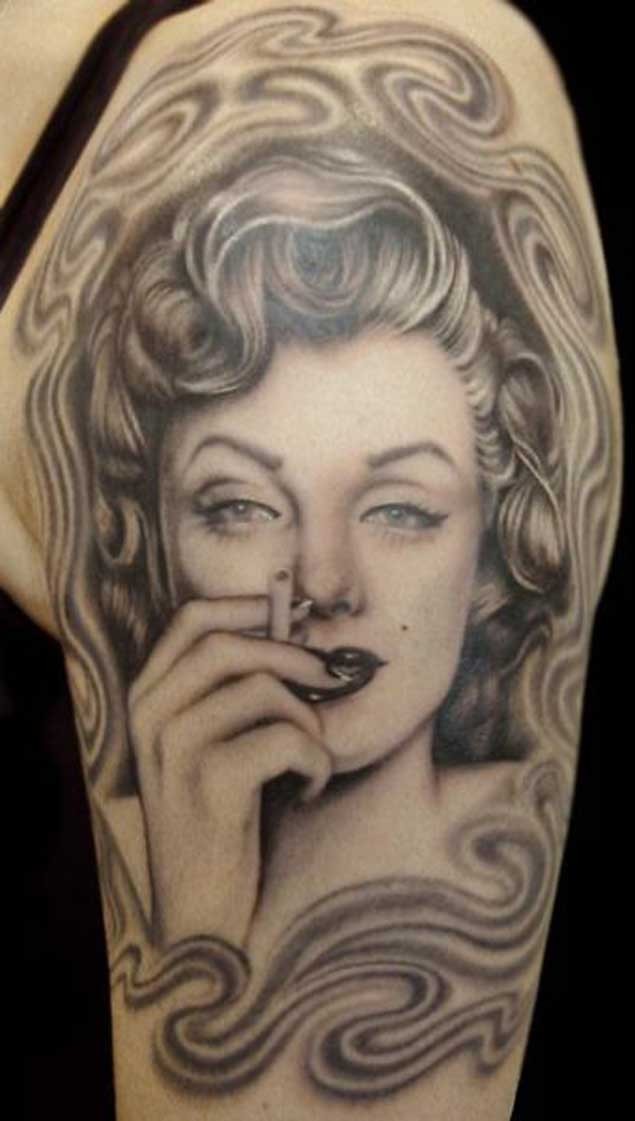 Nice natural looking colored shoulder tattoo of smoking Merlin Monroe portrait