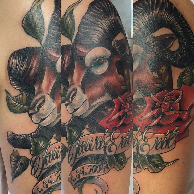 Nice painted natural looking goat tattoo on shoulder with lettering and flowers