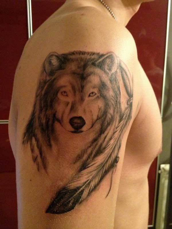 Nice wolf with feather tattoo on arm