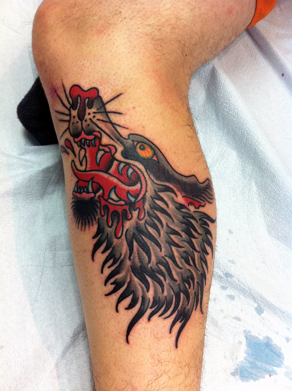 Tatuaggio stilizzato sulla gamba il lupo feroce