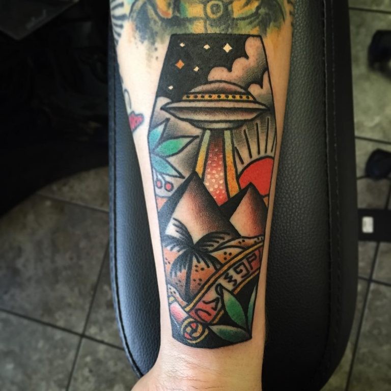Odl school style colored coffin shaped tattoo on forearm stylized with pyramids and alien ship