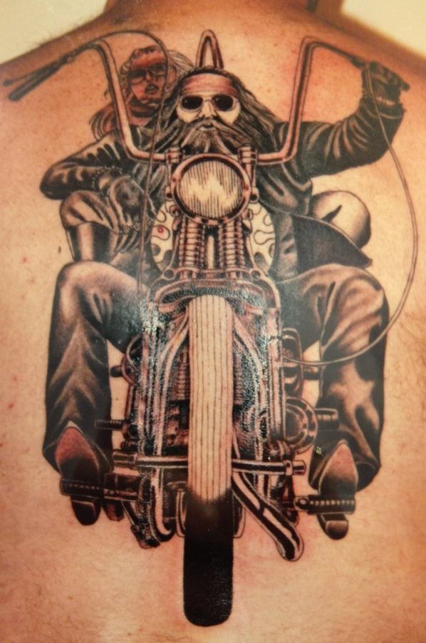 Tatuaje en la espalda,
viejo motorista en su moto