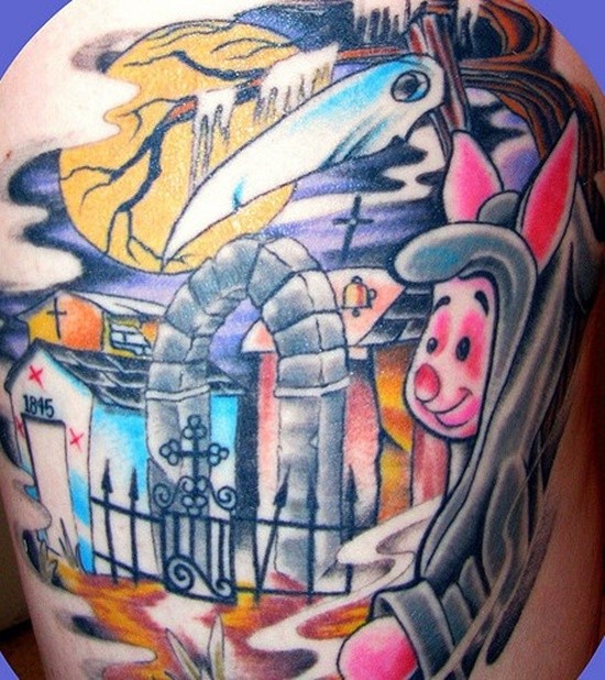 Old cartoon like colored funny pig shaped death tattoo on shoulder with cemetery