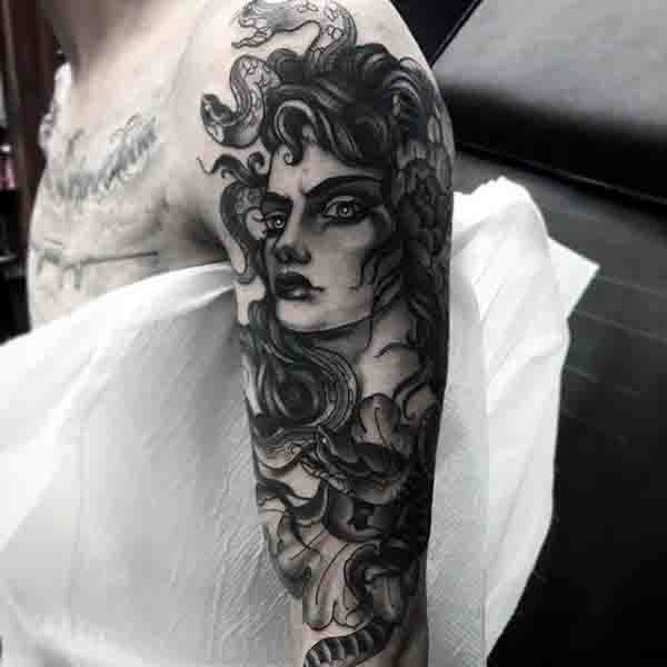 Old cartoon style black ink evil Medusa tattoo on shoulder