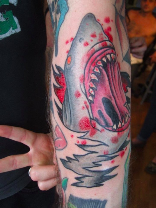 Old cartoon style colored evil bloody shark tattoo on forearm