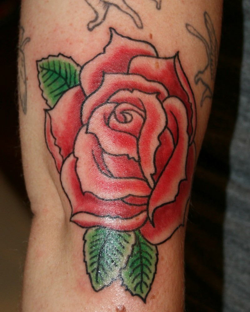 Old cartoons like little red colored rose with leaves tattoo on arm