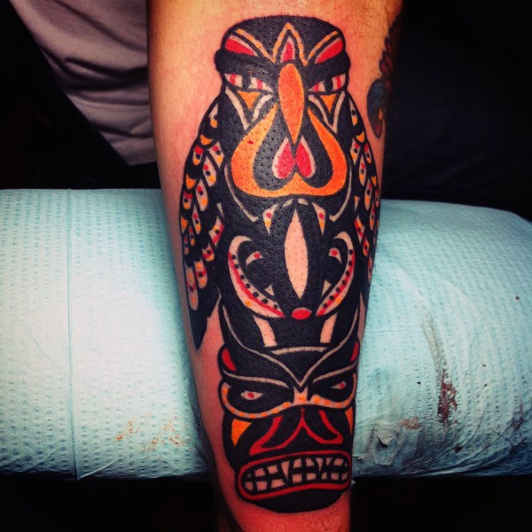 Old cartoons style painted colorful big tribal statue tattoo on arm