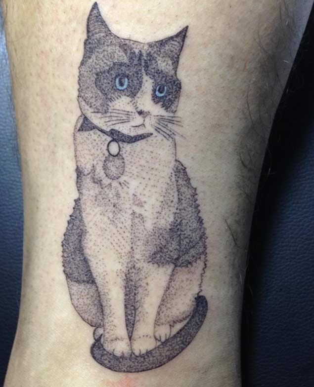 Old looking dot style leg tattoo of cute cat with blue eyes
