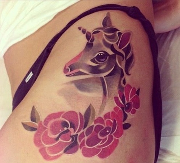 Old school 3D like colored baby unicorn tattoo on thigh combined with flowers