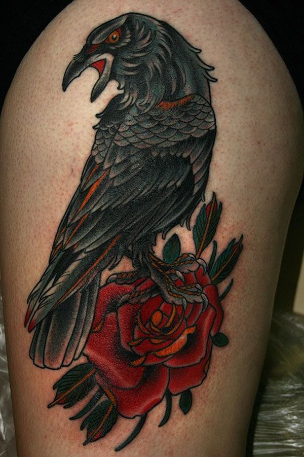 Old school big colored natural looking crow tattoo on thigh with red rose