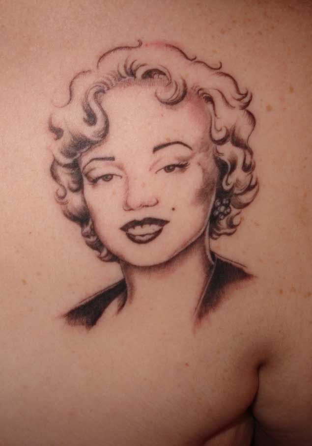Old school black and white back tattoo of smiling Merlin Monroe