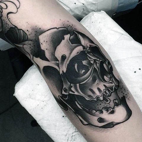 Old school black ink skull tattoo on arm