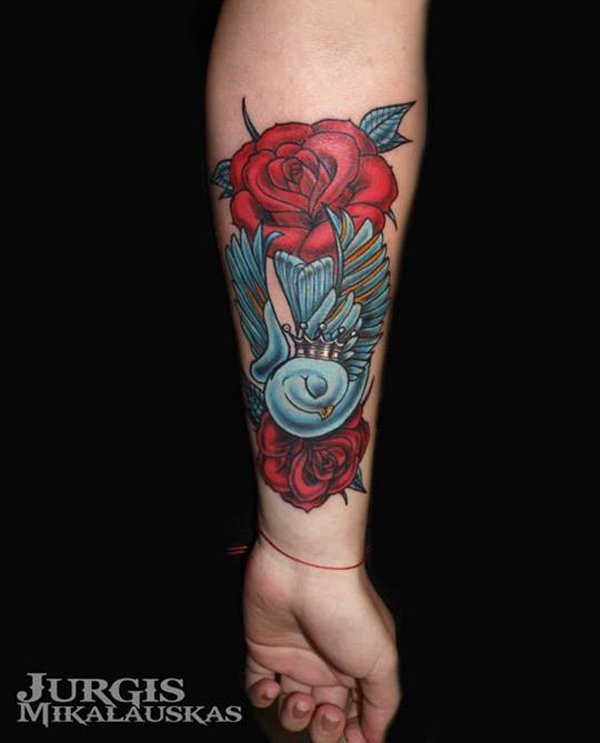 Tattoo von blauem Vogel mit Rose in altschulischem Stil am Unterarm