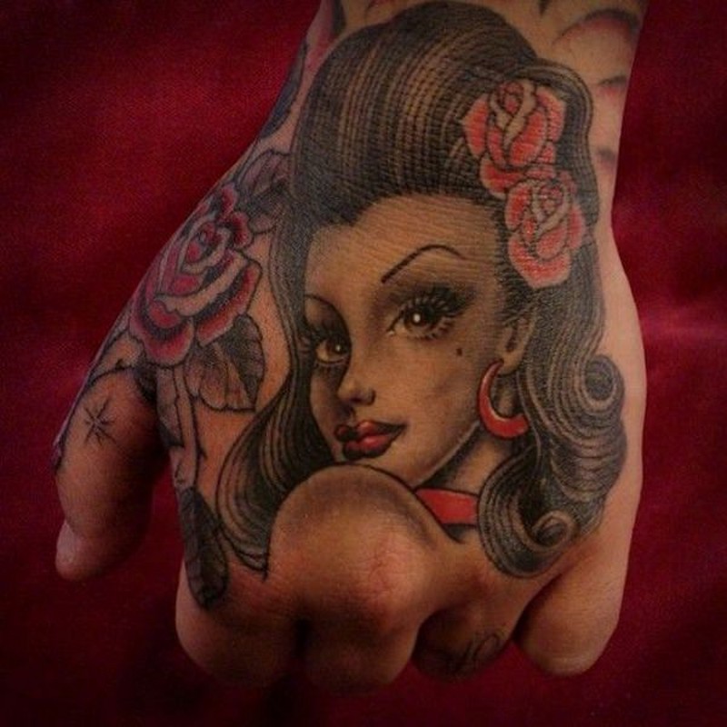 Old school colored beautiful woman portrait tattoo on fist with flowers in hair