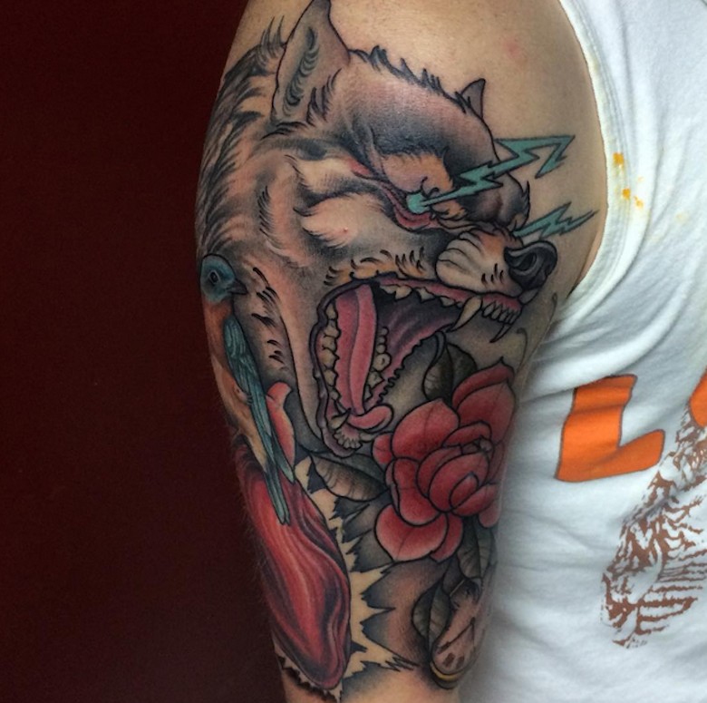 Tatuaje en el brazo, lobo loco con relámpagos de ojos, old school multicolor