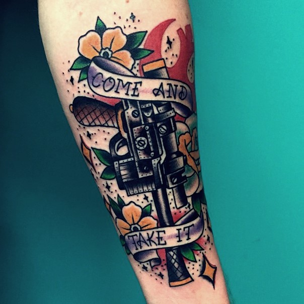 Old school colored detailed Han Solo blaster tattoo on forearm stylized with lettering and flowers