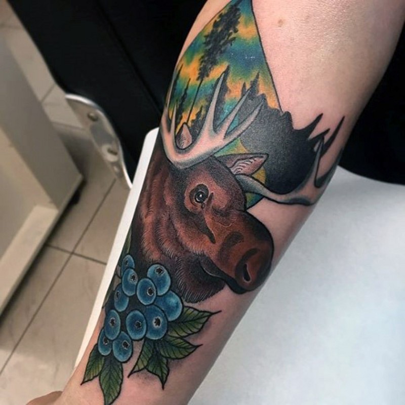 Old school colored forearm tattoo of elk in forest combined with bilberries
