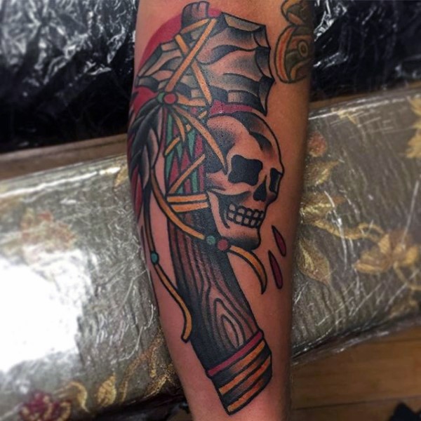 Old school colored Indian axe tattoo on forearm combined with skull