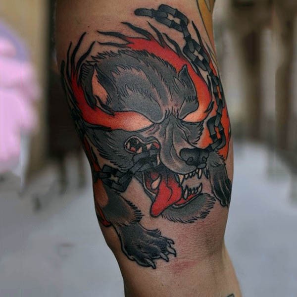 Old school colored little demonic dog tattoo on biceps with chain